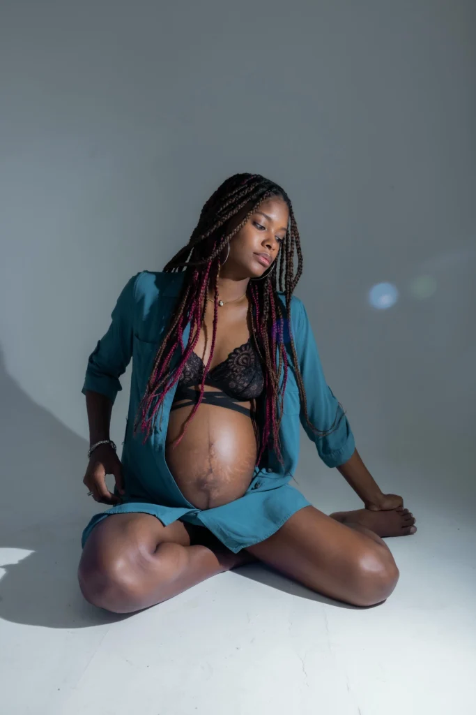 Mujer embarazada posando en un estudio fotográfico en Santo Domingo, con iluminación suave y un fondo neutro que resalta su baby bump.